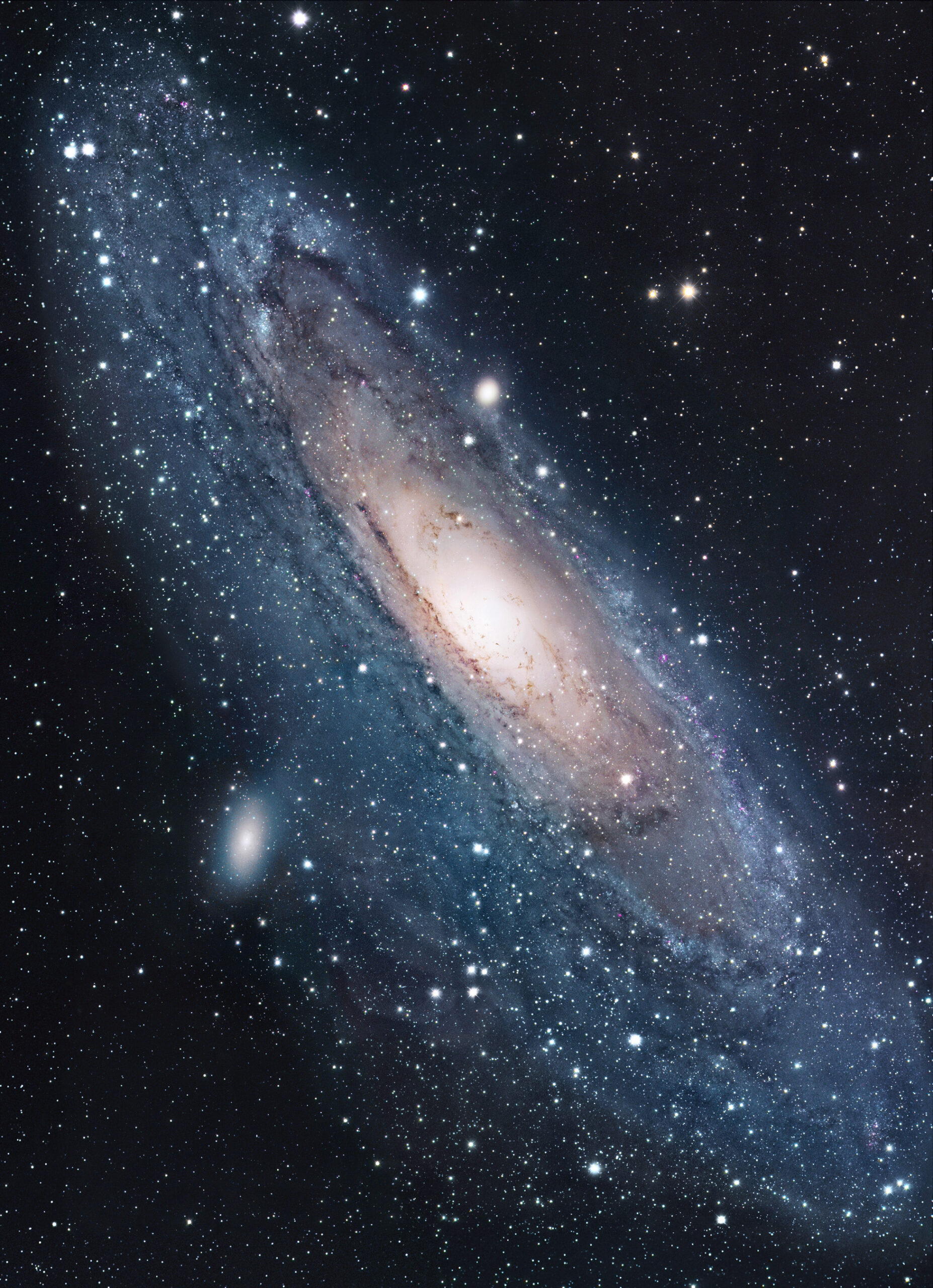Galaktyka Andromedy M31 - rzeczywista fotografia teleskopowa Teleskopowe zdjęcie galaktyki Andromedy M31 z jasnym wydłużonym centrum, spiralnym dyskiem i ciemnymi pasmami pyłu na tle gwiazd